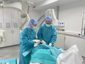 Unsere Fotos, von Prof. Lebiedz aufgenommen, zeigen den Leitenden Oberarzt der operativen Intensivmedizin, Dr. Romulus-Ovidiu Moldovean, im Zusammenspiel mit dem Chefarzt der Radiologie, Dr. Asmus Wulff, bei der Ausführung einer Port-Explantation, d.h., hier wird unter Narkose ein Zugang wieder entfernt.  